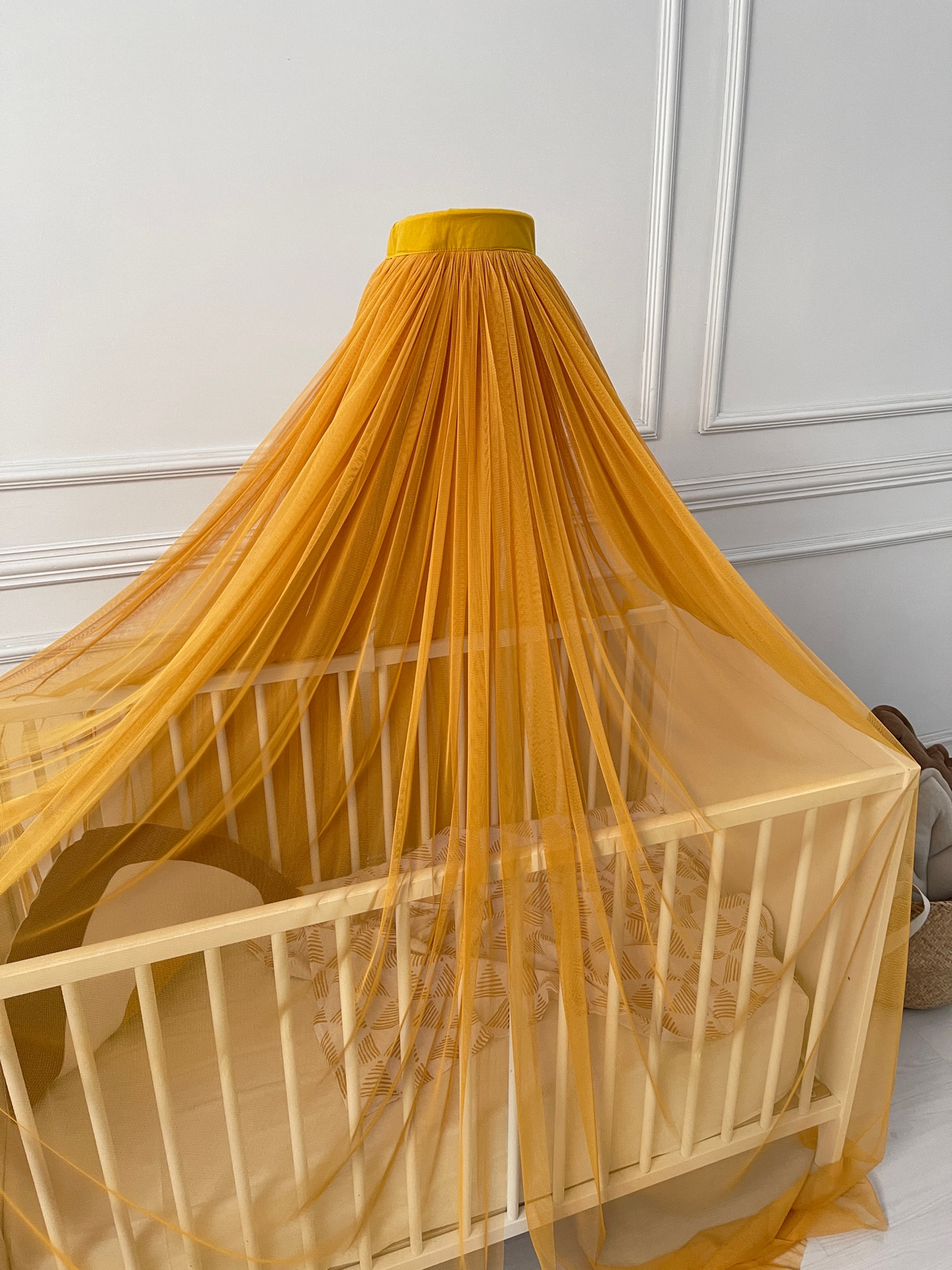 Mustard yellow bed canopy with pompom wreath