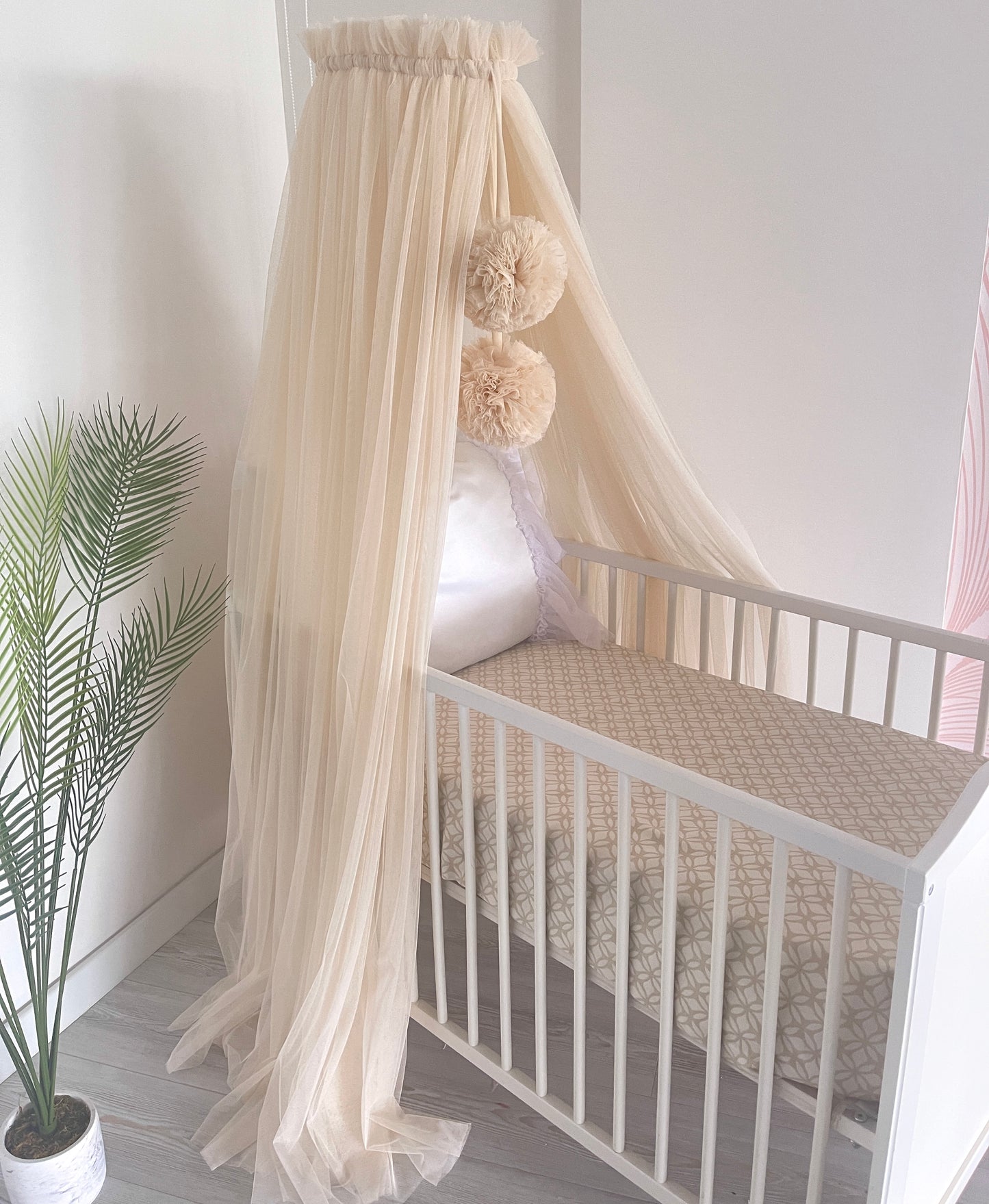 Light beige bed canopy with bobbles