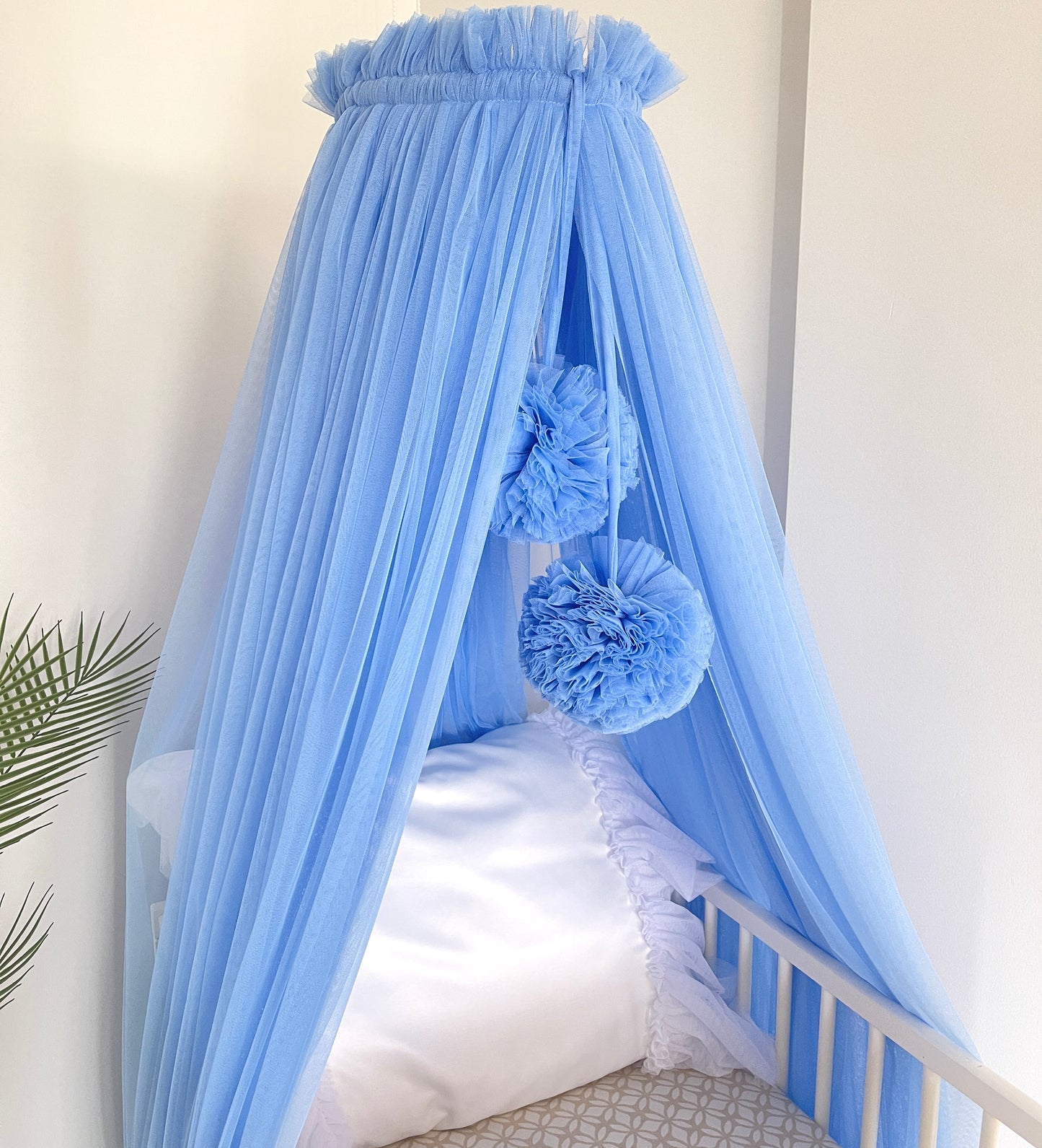 blue bed canopy with pompoms