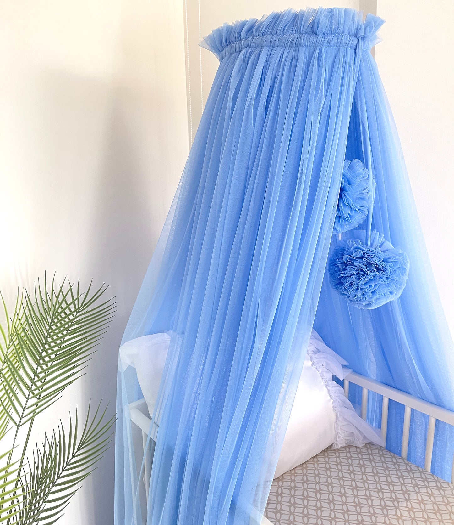 blue bed canopy with pompoms