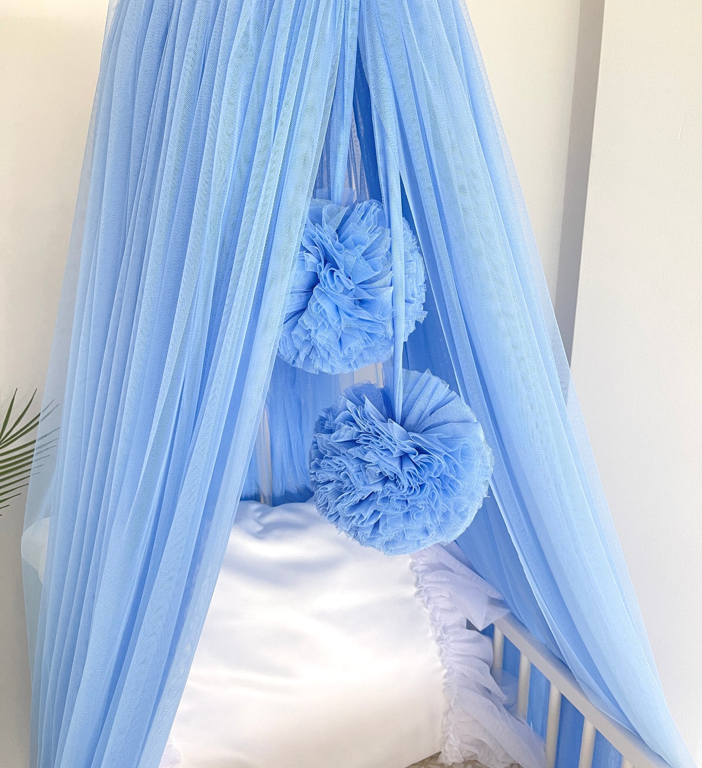 blue bed canopy with pompoms