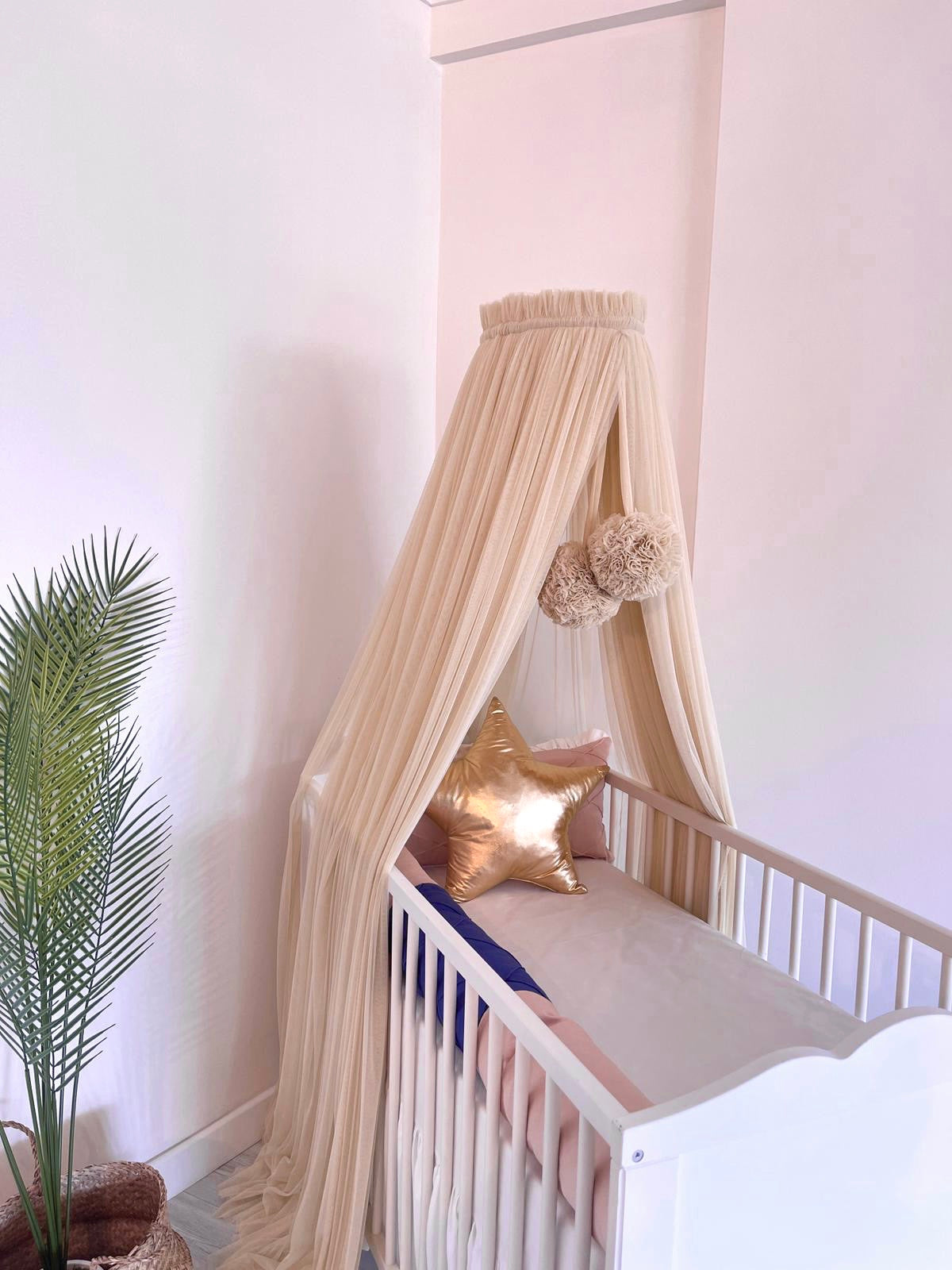 Beige bed canopy with pompoms