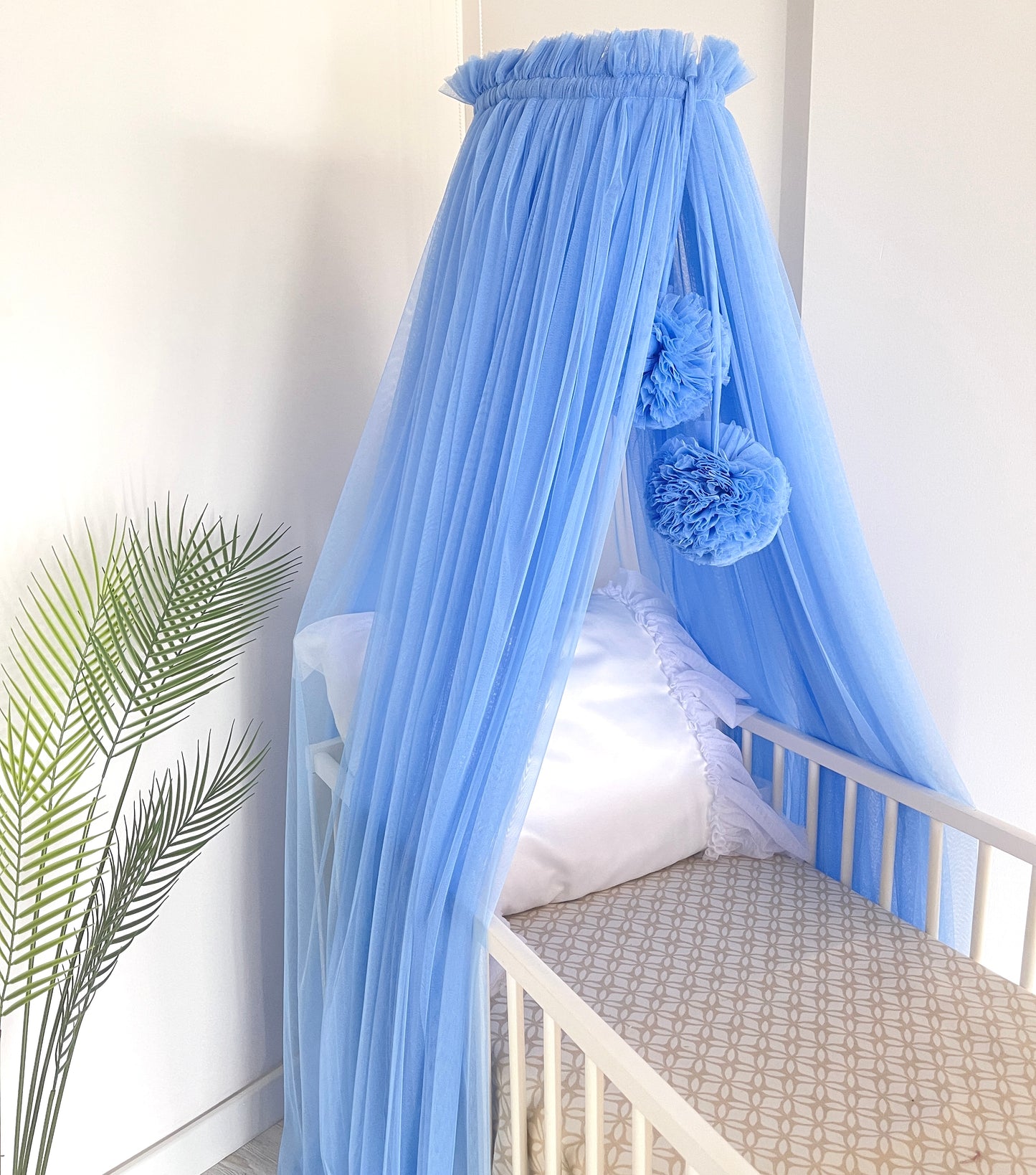 blue bed canopy with pompoms
