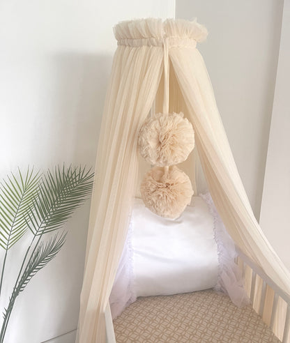Light beige bed canopy with bobbles
