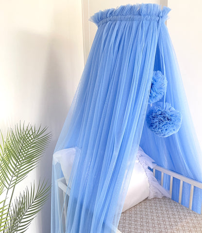 blue bed canopy with pompoms