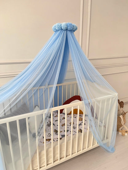 Blue bed canopy with pompom wreath