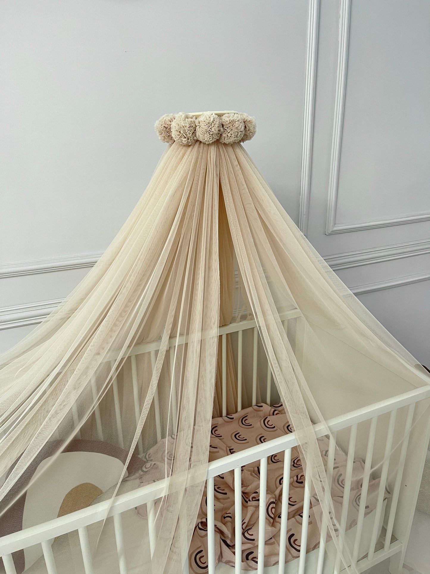 Yellow bed canopy with pompom wreath